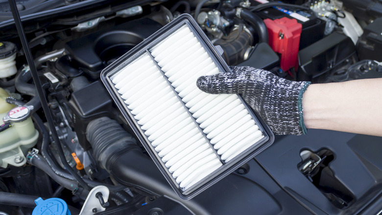 Auto mechanic holding a new air filter