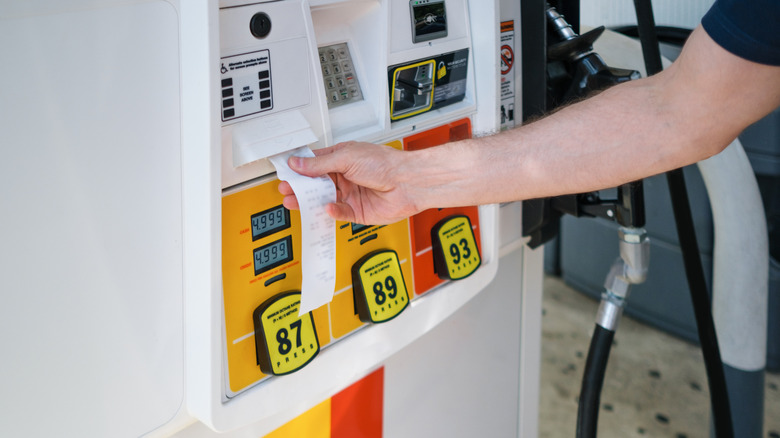 Man grabbing receipt after buying gas