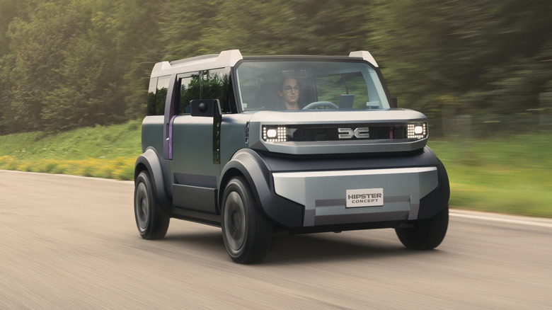 front three-quarters shot of a gray Hipster concept driving past trees and grass
