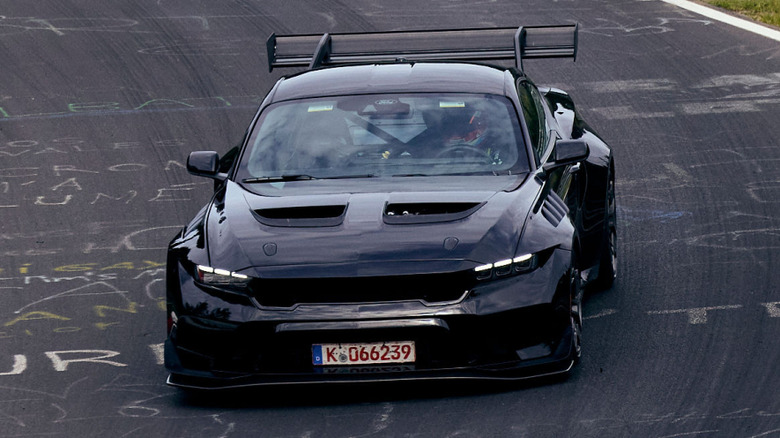 A front view of a black Ford Mustang GTD moving on the Nürburgring